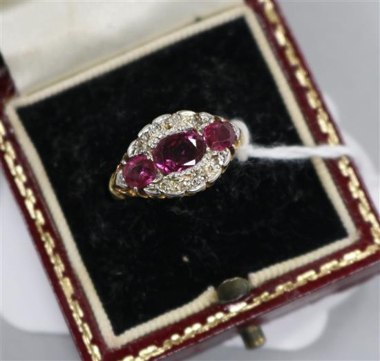 An early 20th century 18ct gold, ruby and diamond oval cluster ring, size K.